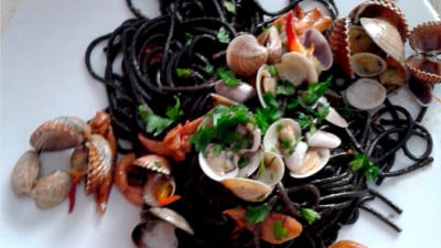 Spaghetti al nero di seppia con frutti di mare e pomodorini